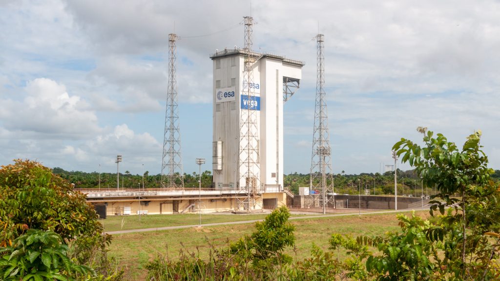 Torre móvil de la zona de lanzamiento Vega, con los logotipos de la ESA y de Vega, rodeada de vegetación en el Centro Espacial de Guayana.