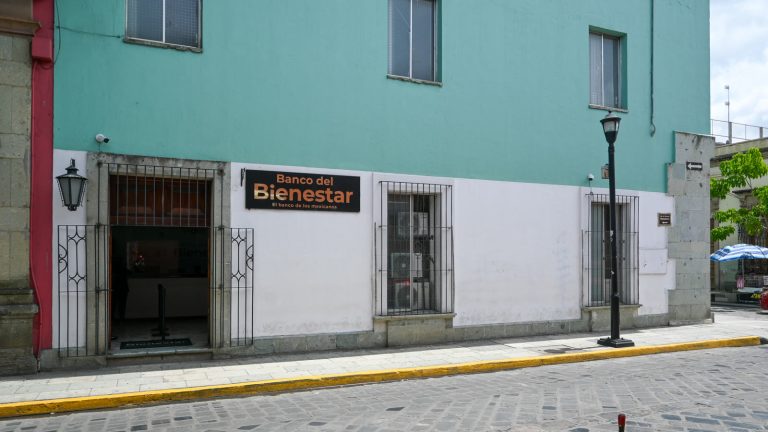 Fachada de una sucursal del Banco del Bienestar en una calle empedrada del centro de Oaxaca.